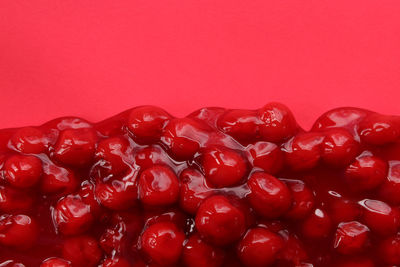 Close-up of red berries over white background