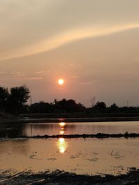 Scenic view of lake against orange sky