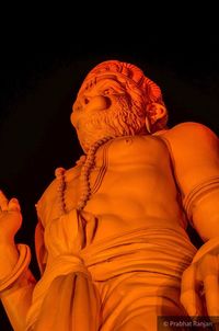 Low angle view of statue against orange wall