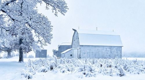 Snow covered barn in snowy white field