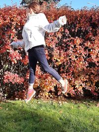 Midsection of woman with umbrella on field during autumn