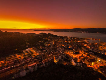 High angle view of illuminated buildings against sky at sunset