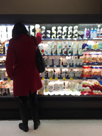 Rear view of a woman standing at store