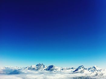 Scenic view of snowcapped mountains against clear blue sky