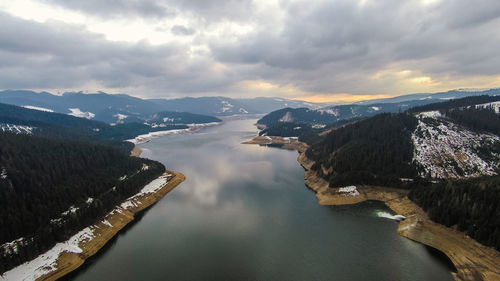 Aerial view of river amidst mountains against sky