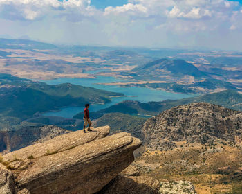 Man looking at view of mountain range against sky