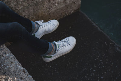 Low section of person sitting on footpath 