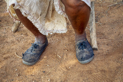 Low section of man standing on mud