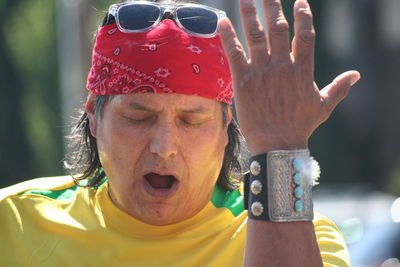 Close-up of man with eyes closed gesturing while singing
