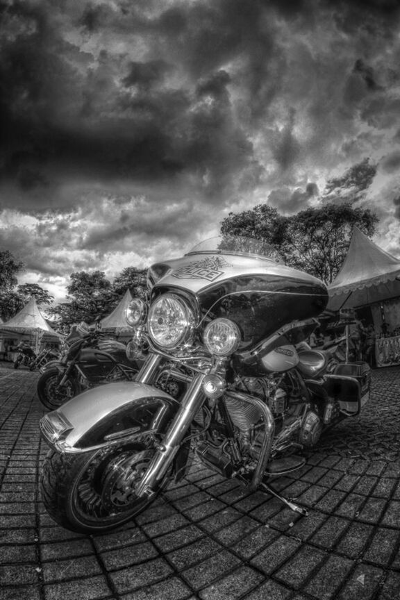 sky, cloud - sky, transportation, land vehicle, bicycle, mode of transport, cloudy, parking, parked, stationary, street, cobblestone, outdoors, cloud, building exterior, day, built structure, tree, architecture, footpath