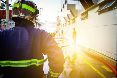 Rear view of firefighter standing on street