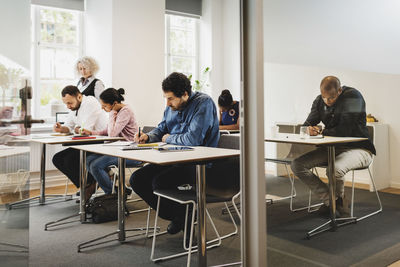 Teacher looking at students writing in language class