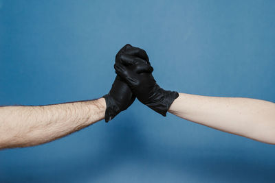 Close-up of man hand against blue background