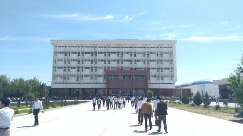 Group of people walking in front of buildings