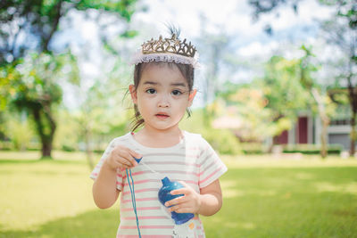 Portrait of girl holding bubble wand at park