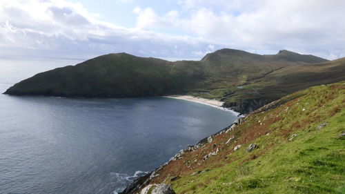 Scenic view of sea and mountains against sky