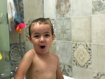 Portrait of shirtless boy in bathroom