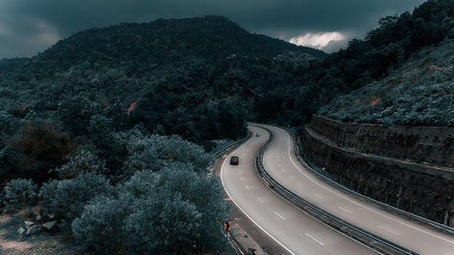 High angle view of road amidst trees against sky