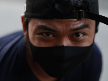 Close-up portrait of young man covering face