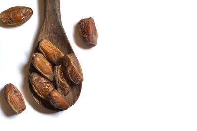 High angle view of roasted coffee beans against white background