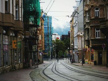 Railroad tracks in city against sky