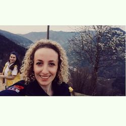 Portrait of smiling young woman against clear sky