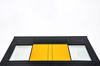 Low angle view of yellow building against clear sky