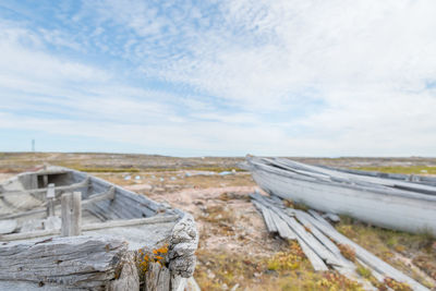 Abandoned boats on landscape against sky