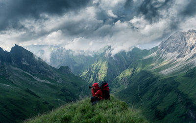 Rear view of people on mountains against sky