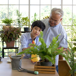 Happy friends and potted plants on table