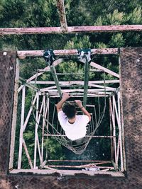 High angle view of man moving down on ladder