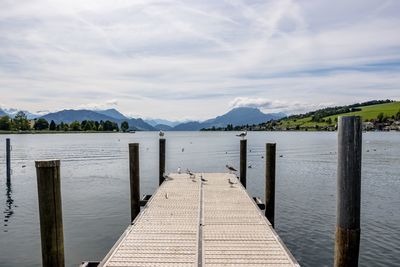 Wooden pier over lake against sky