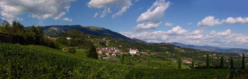 Panoramic view of townscape by mountains against sky