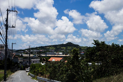 Road by trees against sky
