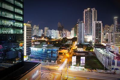 Illuminated buildings in city against sky at night