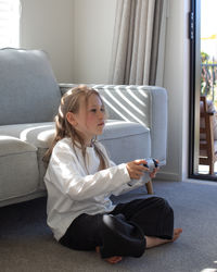 Portrait of young woman sitting on sofa at home