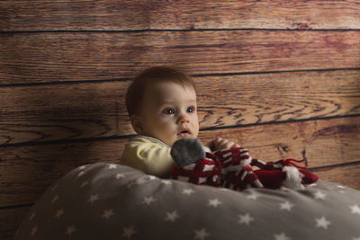 Portrait of cute baby boy on wooden floor