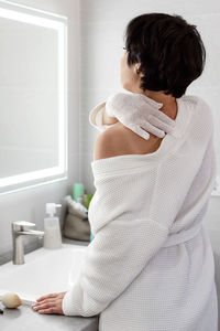 Side view of young woman sitting at home