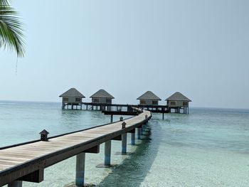 Built structure on pier by sea against clear sky