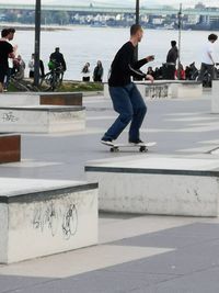 Group of people skateboarding on shore