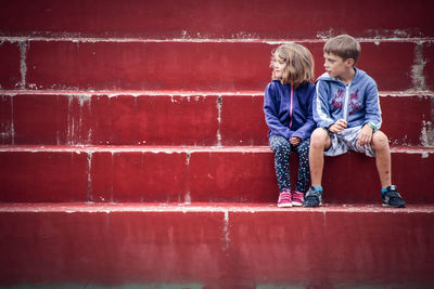 Full length of siblings sitting on steps 