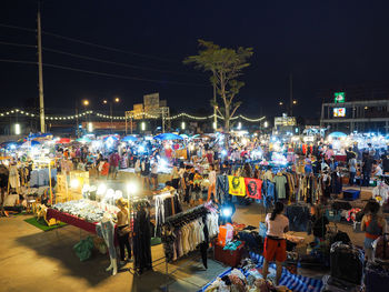 People on illuminated street market at night