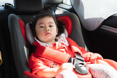 Close-up portrait of cute girl sitting in car