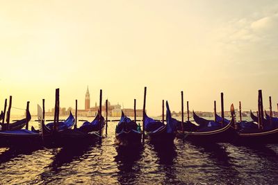 Gondolas moored at grand canal against sky during sunset 