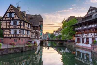 Reflection of buildings in river against sky