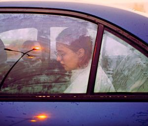 Portrait of woman seen through car window