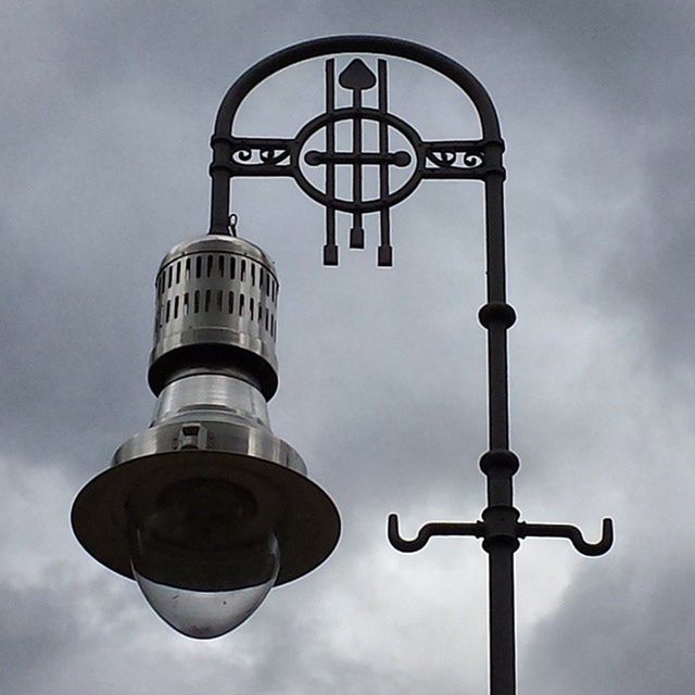 low angle view, communication, sky, guidance, text, architecture, built structure, cloud - sky, road sign, street light, sign, building exterior, information sign, direction, tower, lighting equipment, cloud, safety, day, western script