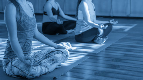 Low section of woman sitting on wooden floor