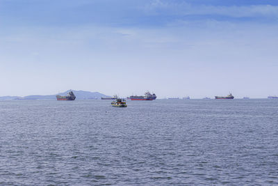 Boats sailing in sea against sky