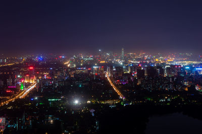 High angle view of illuminated buildings in city at night